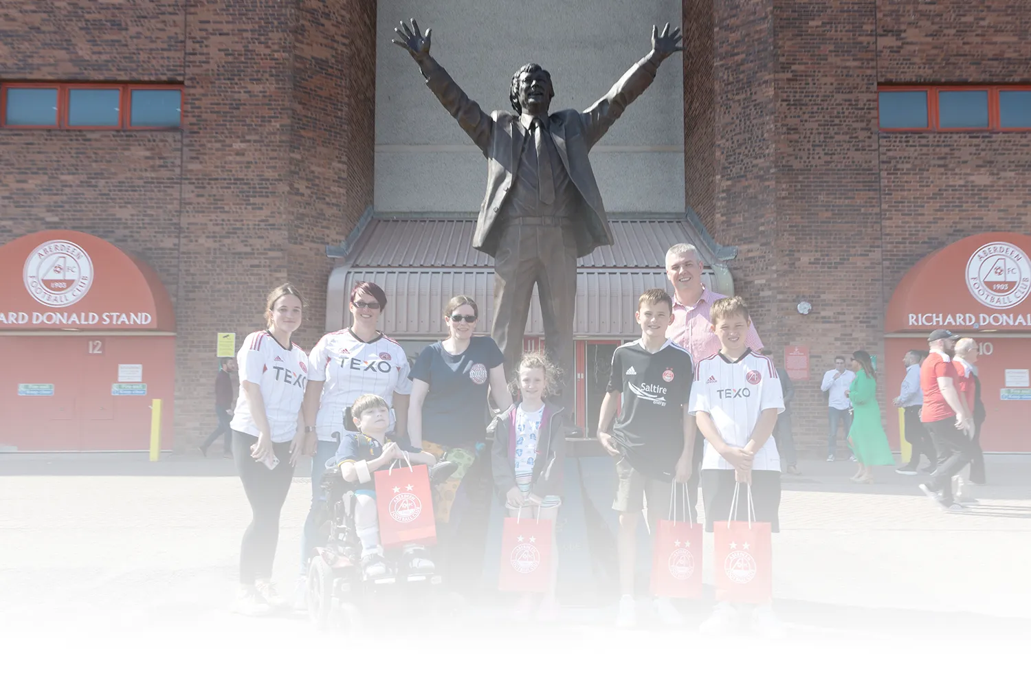 Fans gather outside statue of Sir Alex Ferguson at a Dons Day out